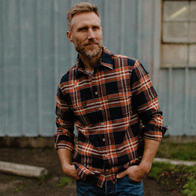 fit model facing camera with hands in pocket in The Ledge Shirt in Rust Plaid