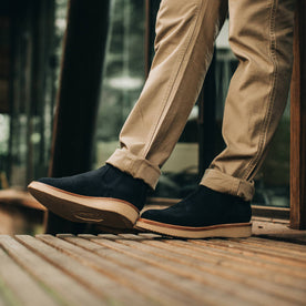 our fit model wearing The Ranch Low in Weatherproof Navy Suede—against a wall, pants cuffed
