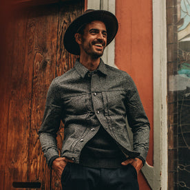 fit model wering flatlay of The Dispatch Jacket in Navy Jaspe, smiling, hands in pockets