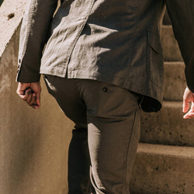 our fit model wearing The Gibson Trouser in Gravel—walking up stairs, back shot