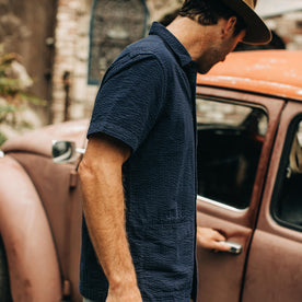 our fit model wearing The Caravan Shirt in Navy Seersucker—cropped shot near car