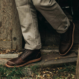 our fit model wearing The Moto Boot in Chocolate Pebble Grain—walking left