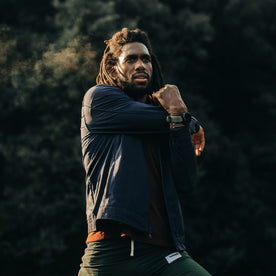 fit model wearing The Park Bomber in Navy, stretching