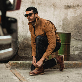 fit model wearing The Wyatt Jacket in Cognac Suede, tying his boots