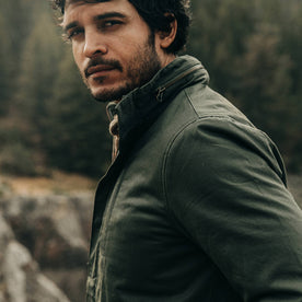 our fit model wearing The Harris Jacket in Forest Dry Wax—cropped shot looking at camera