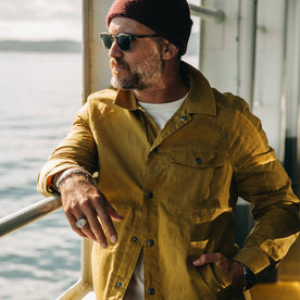 fit model wearing The Lombardi Jacket in Mustard Dry Wax, looking left