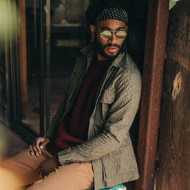 fit model wearing The BDU Shirt Jacket in Rain Drop Camo, sitting, sunglasses on