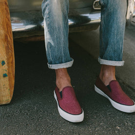 fit model wearing The Sano Slip-On in Rust Boss Duck, sitting on back of car