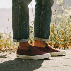 fit model wearing The Sano Slip-On in Rust Boss Duck, standing near grass