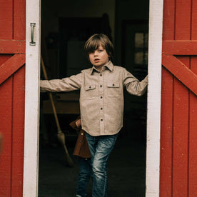 our fit model wearing The Little Yosemite Shirt in Oat Donegal—standing near a barn