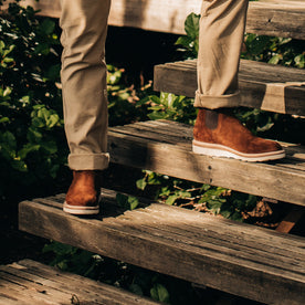 our fit model wearing The Ranch Boot in Weatherproof Snuff Suede—standing at an angle on a deck