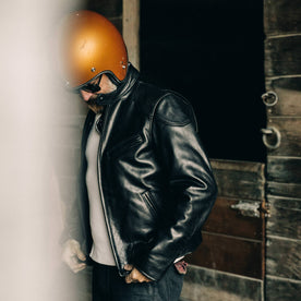 our fit model wearing The Band Collar Moto Jacket—looking down, helmet on