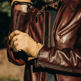 our fit model wearing The Band Collar Moto Jacket—playing with zipper on wrist
