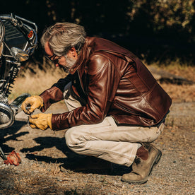 our fit model wearing The Band Collar Moto Jacket—working on bike