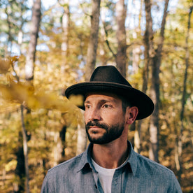 fit model wearing The Packable Lane Splitter in Espresso, standing outside in fall leaves
